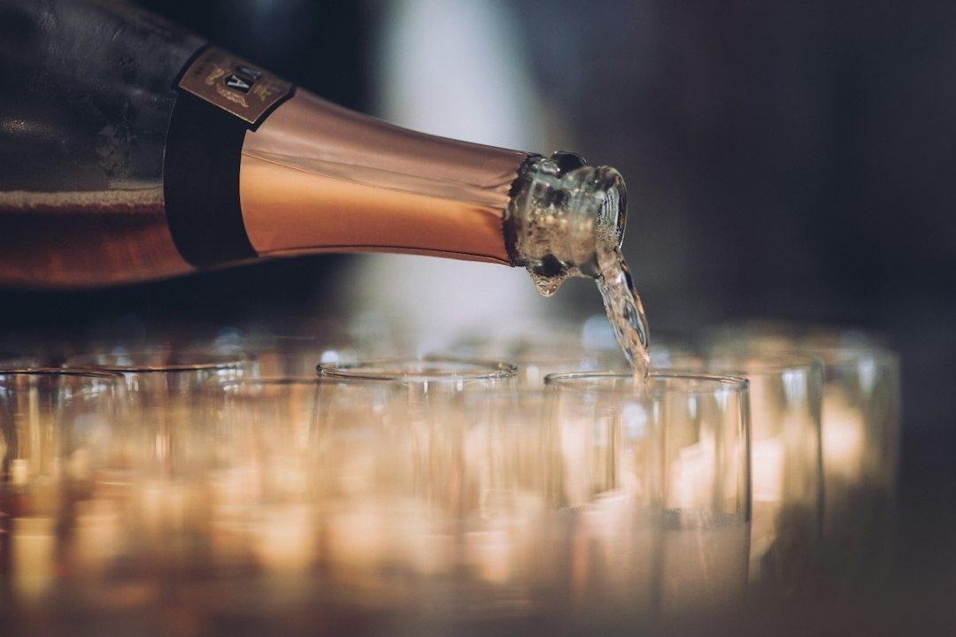 Bouteille de vin effervescent versant dans des verres alignés